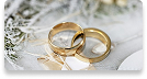Alianças douradas de casamento com o fundo claro